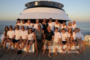 grupo de buceadores posando en la proa del barco