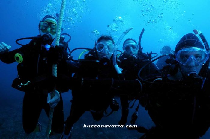 buceadores agarrados al cabo del ancla